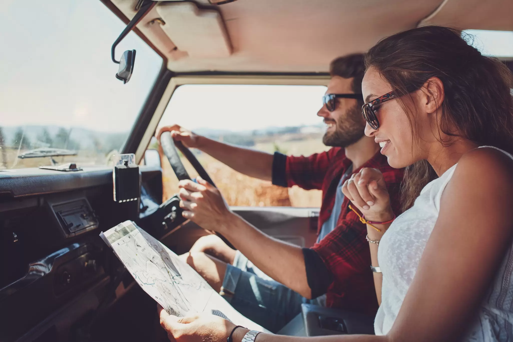 Side view of young couple using a map on a roadtrip for directions. Young man and woman reading a map while sitting in a car.  License Type: media  Download Time: 2023-11-13T12:49:19.000Z  User:   Is Editorial: No  purchase_order: