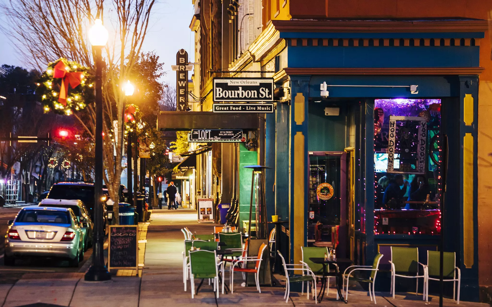 A view down the street at night of the Front Street Brewery sign in Wilmington, North Carolina