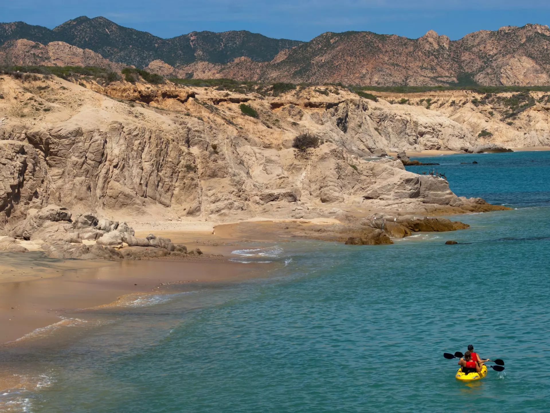 Two empty kayaks on a beach