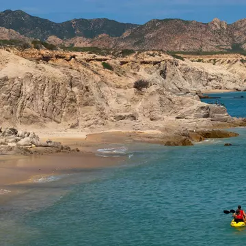 Two empty kayaks on a beach