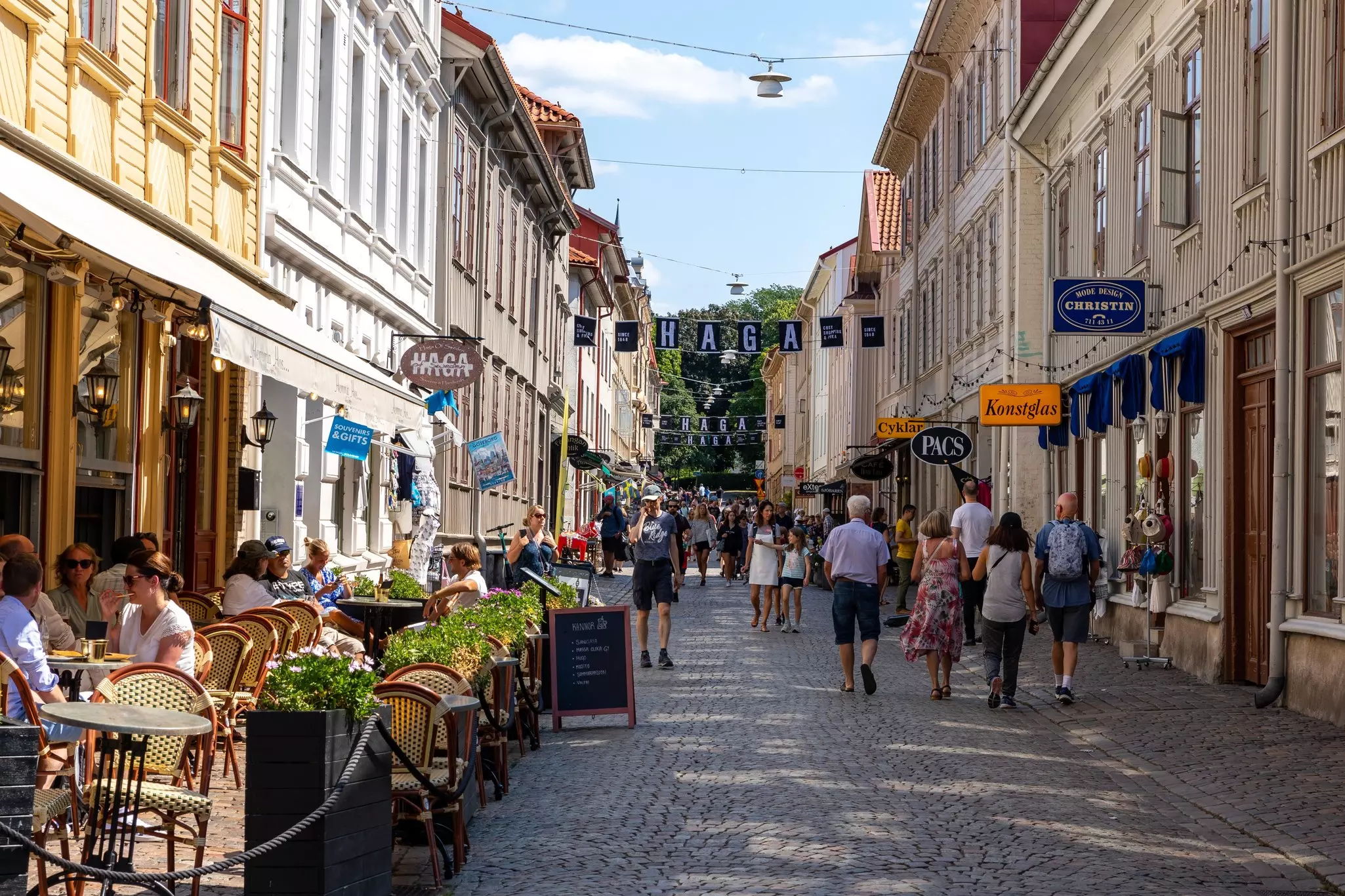 People enjoying the sunshine on cafe terraces of an old town street