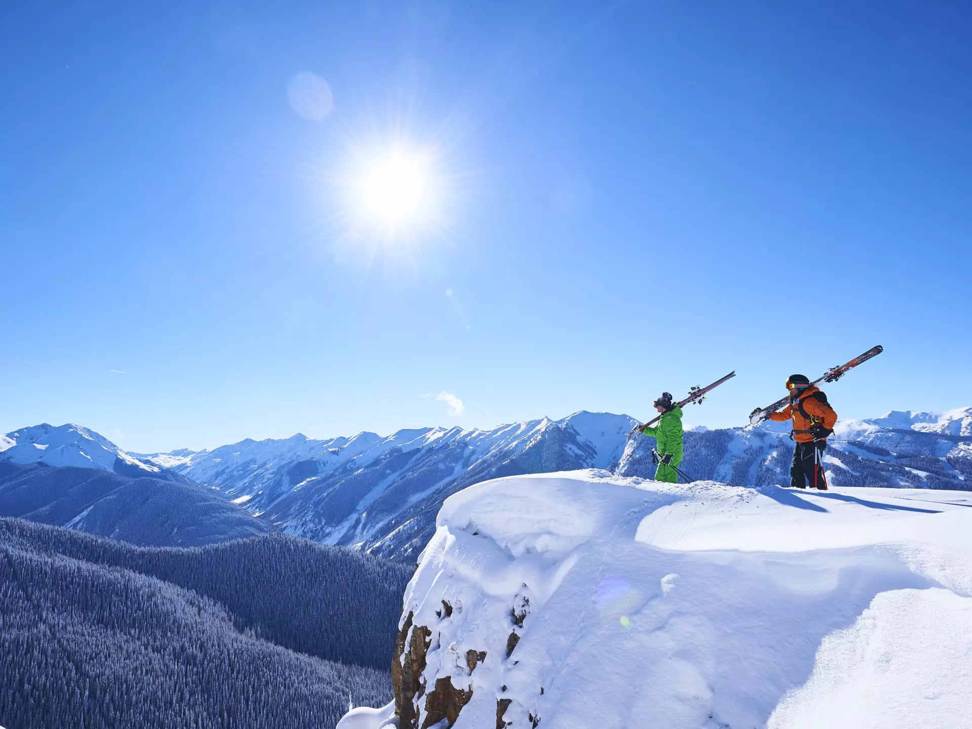 Two skiers take in the snowy views of Aspen, Colorado