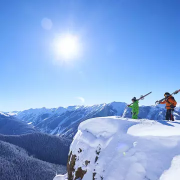 Two skiers take in the snowy views of Aspen, Colorado