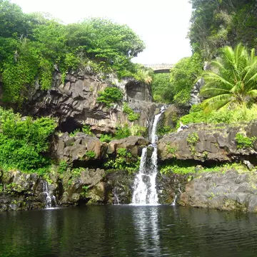 A waterfall and pool surrounded by lush forest at O'heo Gulch, Seven Sacred Pools