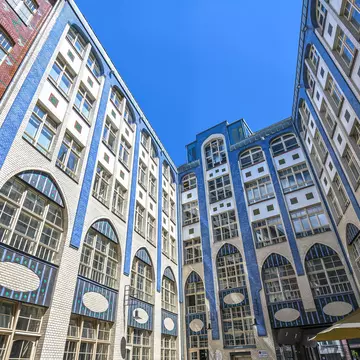 A series of row houses and front walls, each a bright pastel shade of pink, green, orange, yellow and red, flank either side of the street © Nicky Classen / Lonely Planet © espiegle / Getty Images