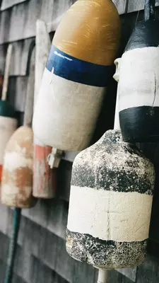 Colorful fishing bouys hang on the side of a building 