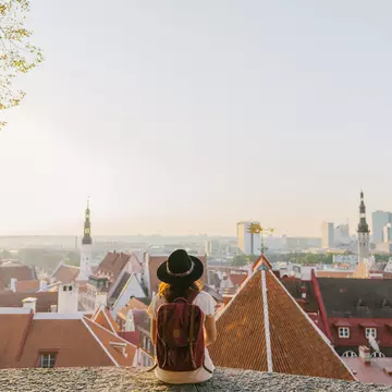 Young Caucasian woman sitting and looking at Tallinn in the morning