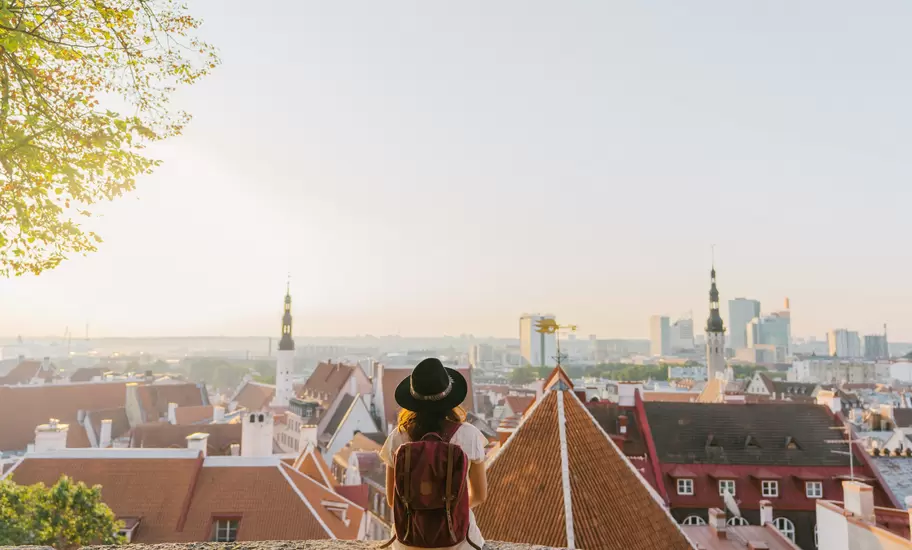 Young Caucasian woman sitting and looking at Tallinn in the morning