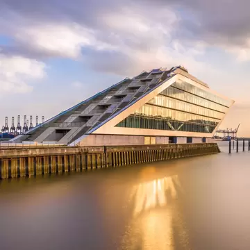 The Dockland is a striking office building with a staircase accessible for visitors and a view over the harbor in Hamburg, Germany.