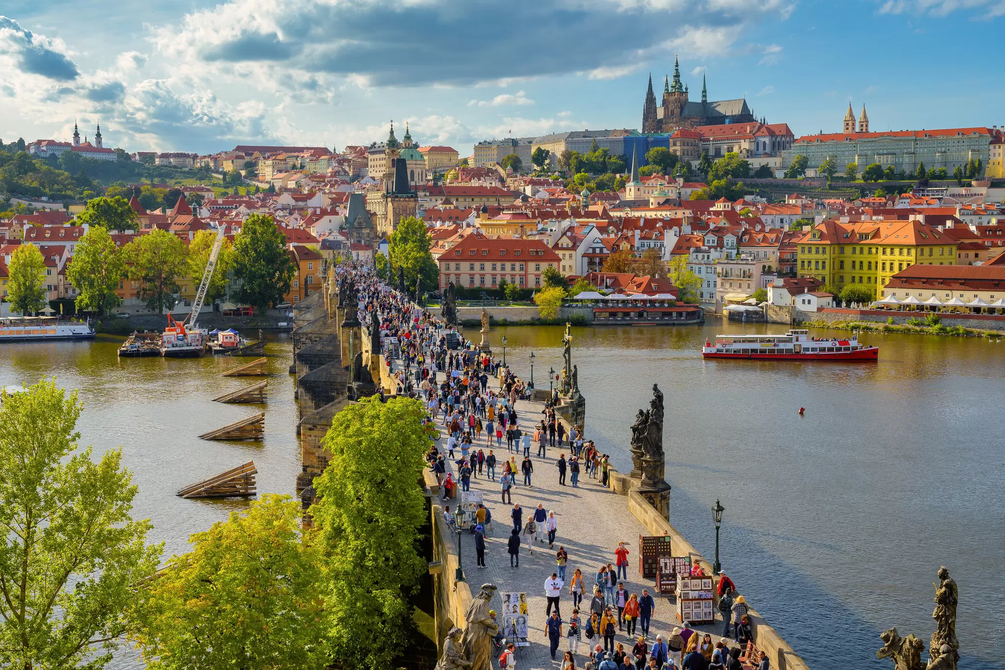 Aerial view of crowds on the Charles Bridge on a sunny day in Prague, Czechia.