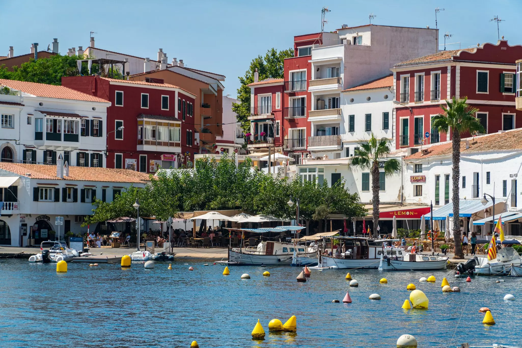 A small port surrounded by red and white apartment buildings and restaurants