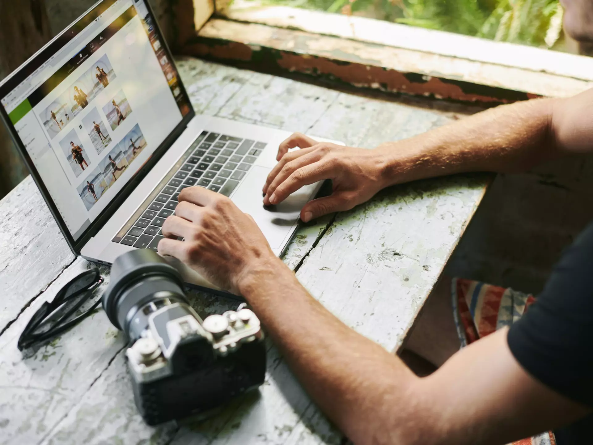 Male on laptop in beach hut.