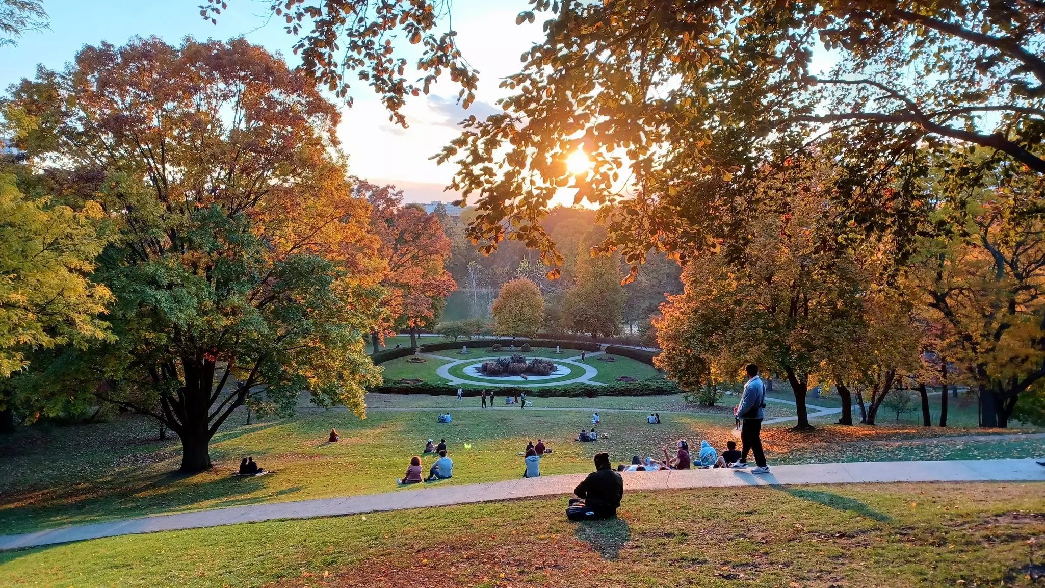 People enjoying the view at sunset in Toronto's High Park on a warm fall evening