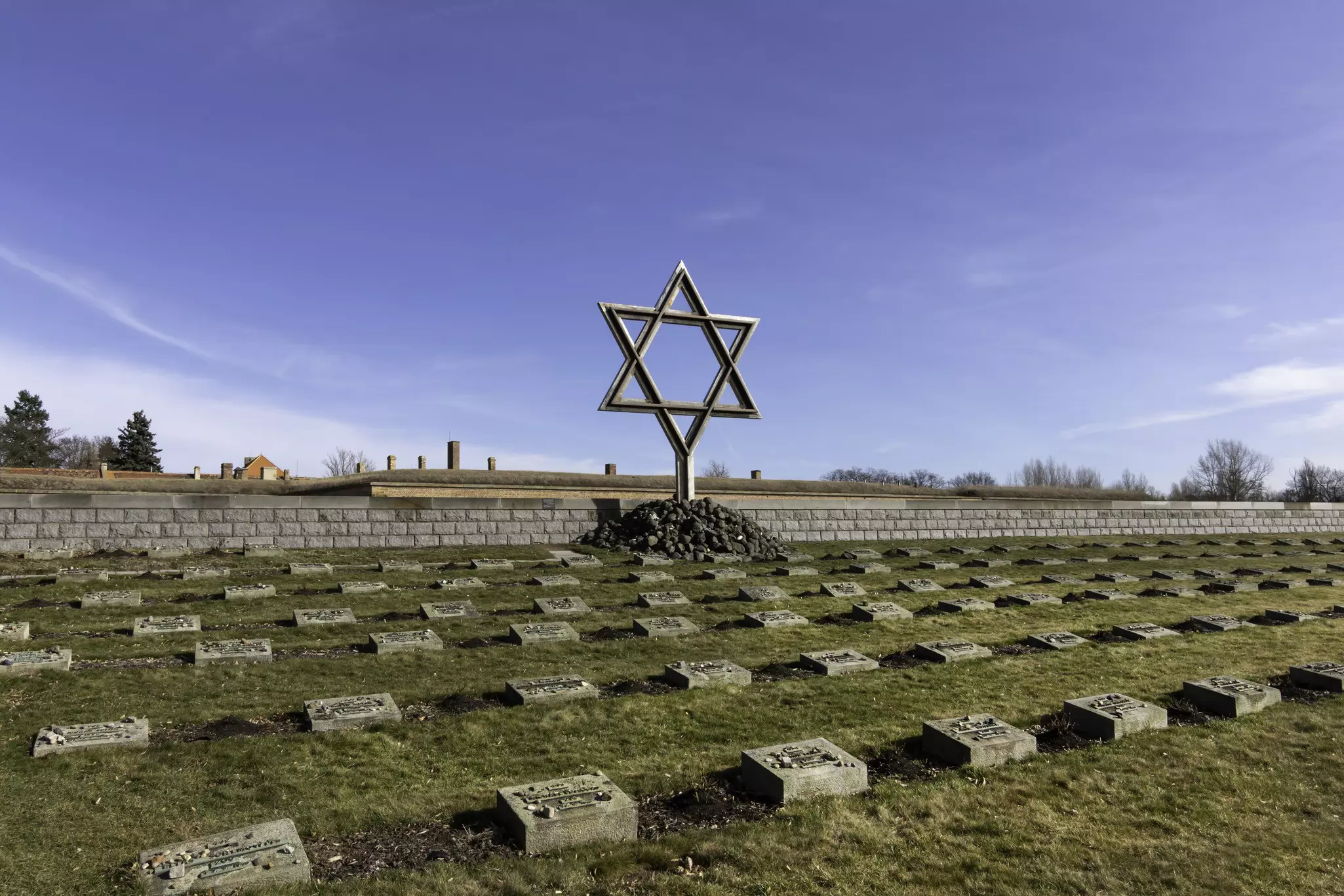 A large Star of David is erected in the middle of a cemetery in Czechia.
