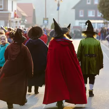 A group of people dressed as witches walk together down a street on Walpurgisnacht (Walpurgis Night), Germany
