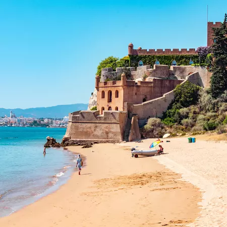 A castle overlooking a beach on a sunny day