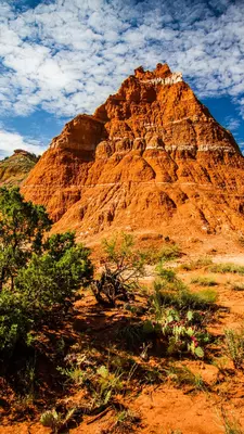 A pyramid-shaped rock formation is brightly lit by the sun.