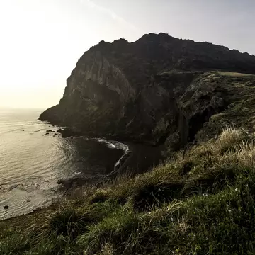 Scenic view of sea and hill at sunrise, Seongsan Ichulbong.