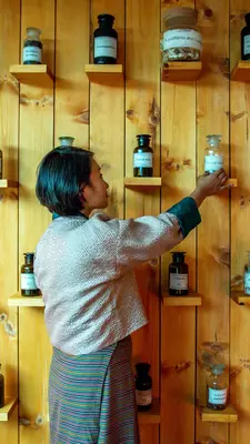 A woman selects a bottle from a wall of options.