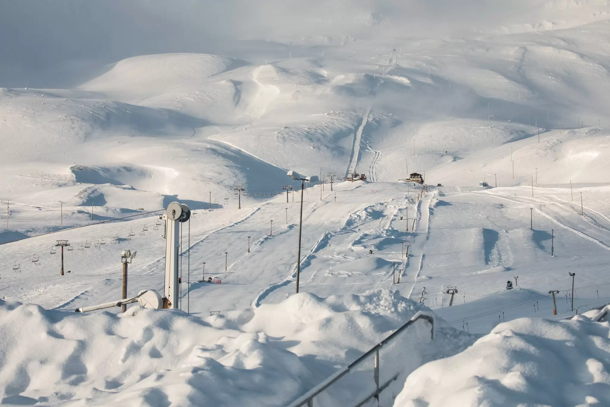 Numerous lifts across the snow-covered hills of the Hlíðarfjall ski resort.