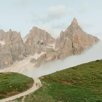 Orla Thomas and guide Narciso Simion walking near Pale di San Martino