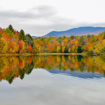 Autumn forest and mountains reflected in the Waterbury Reservoir near Stowe, Vermont