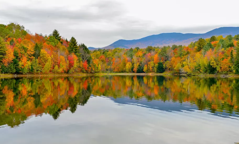 Autumn forest and mountains reflected in the Waterbury Reservoir near Stowe, Vermont