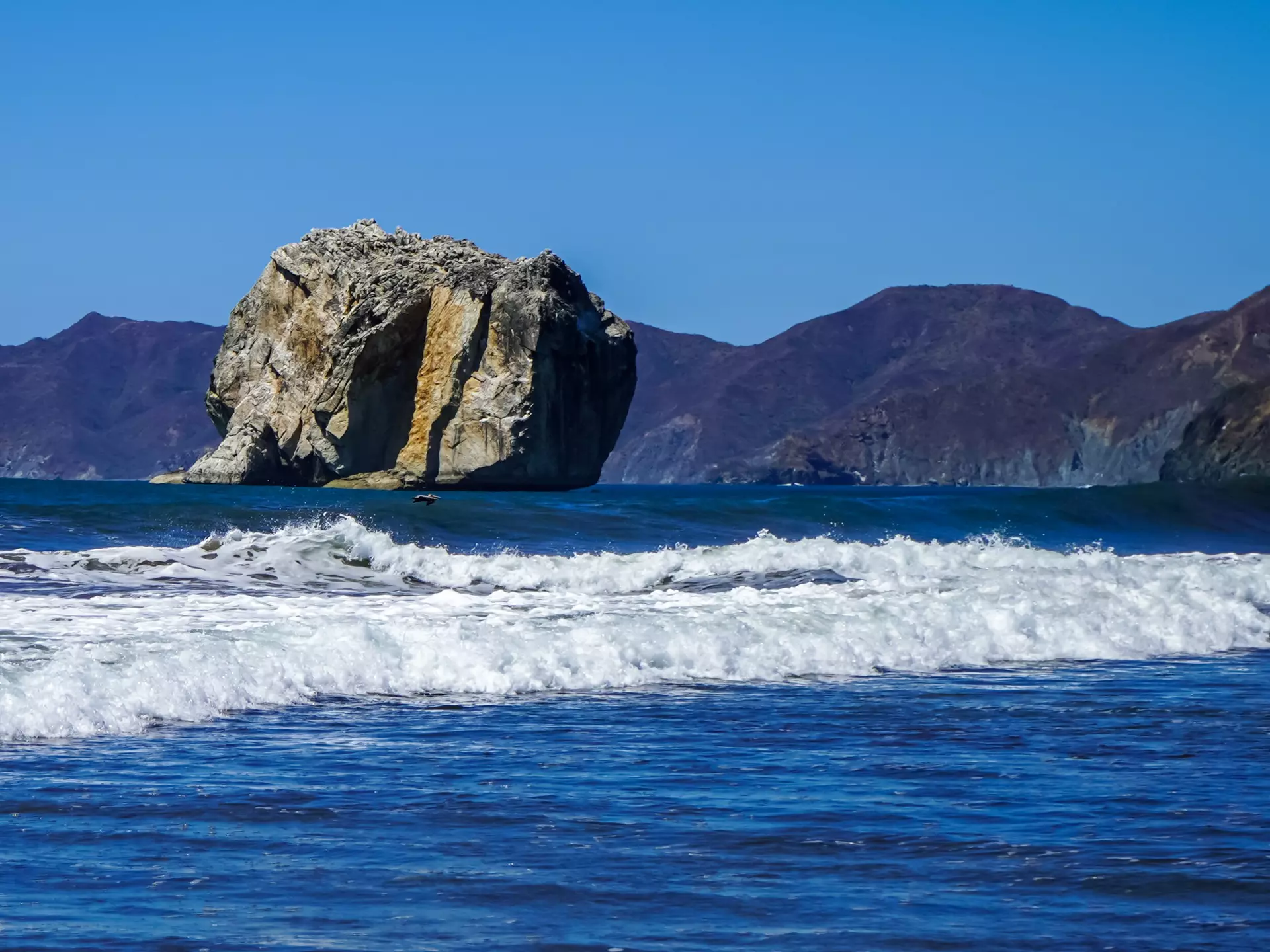 a large rock jutting from the ocean in Costa Rica