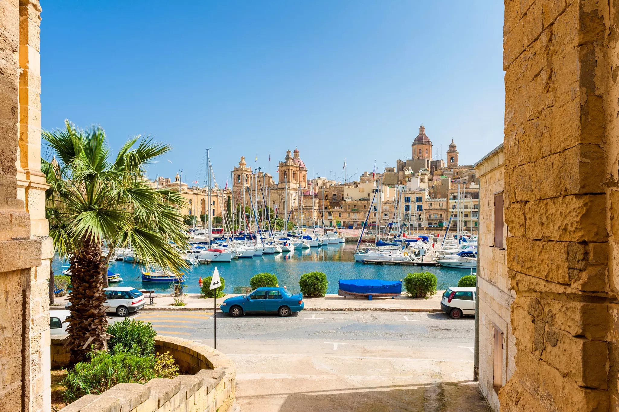 A view of a street and marina in Senglea, with buildings in the background.