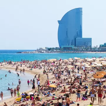 Barceloneta Beach against W Barcelona Hotel in Barcelona, Spain.  Barceloneta Beach - one of the most popular in the city. @BearFotos/Shutterstock