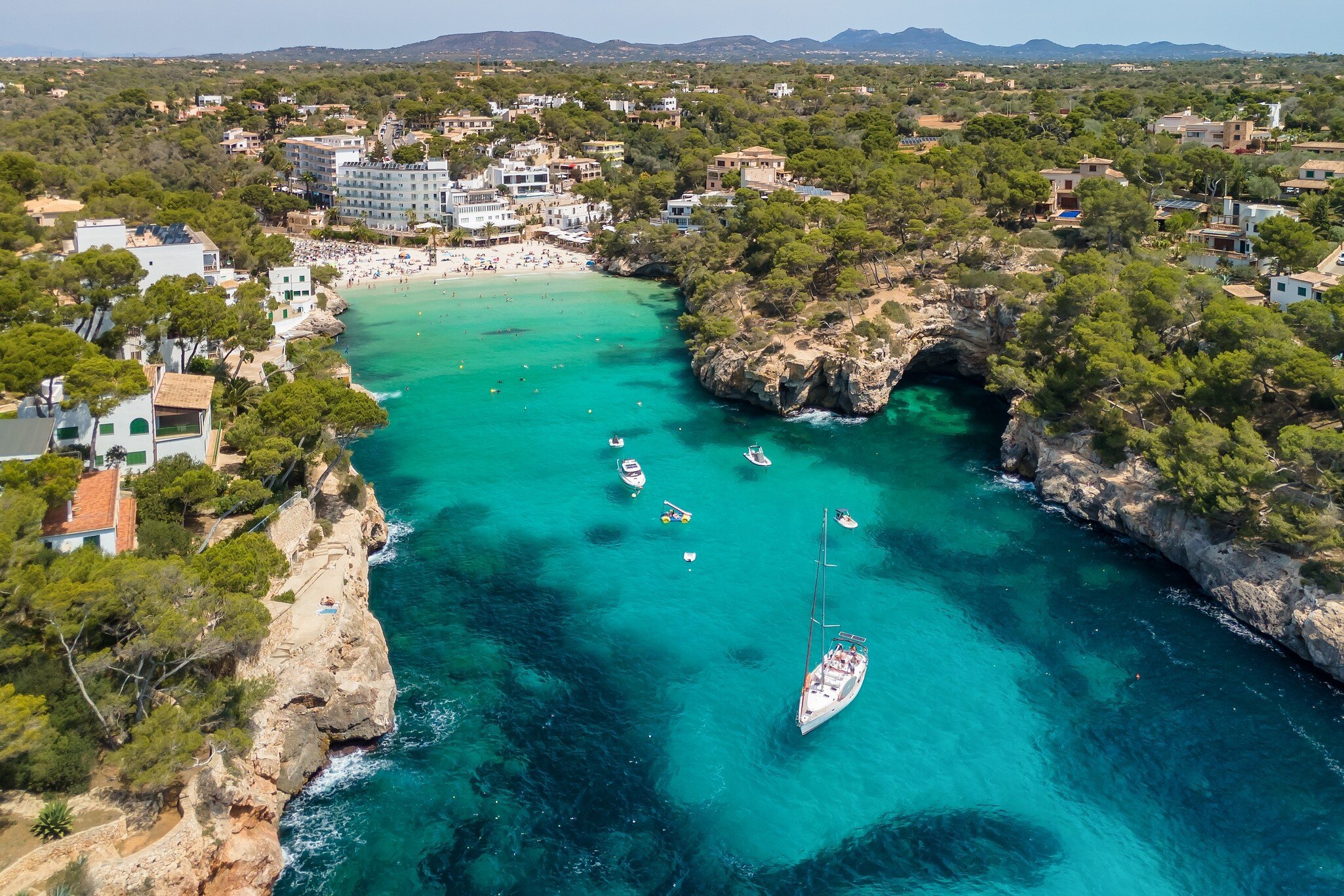 Arial view of a beach surrounded by rocky cliffs.