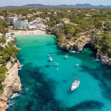 Arial view of a beach surrounded by rocky cliffs.