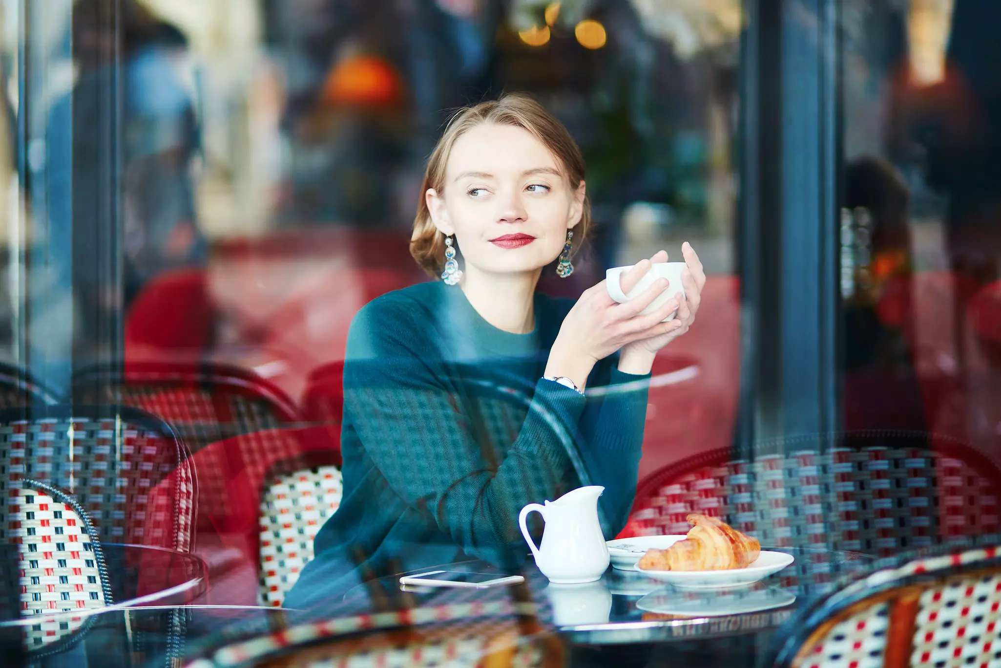 Young elegant woman drinking coffee in cafe in Paris, France