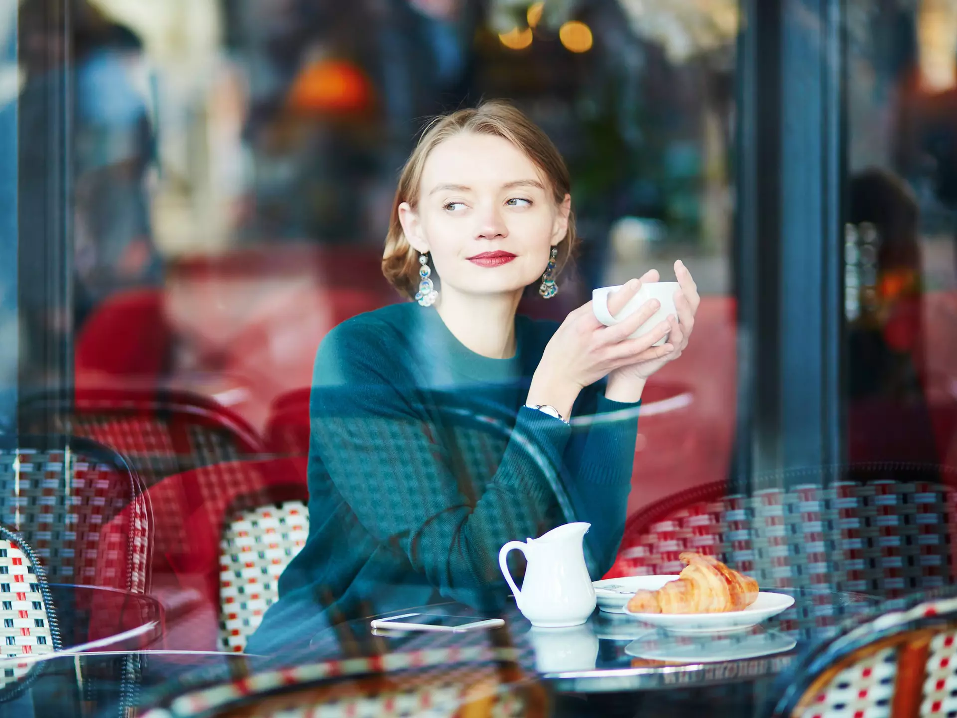 Young elegant woman drinking coffee in cafe in Paris, France