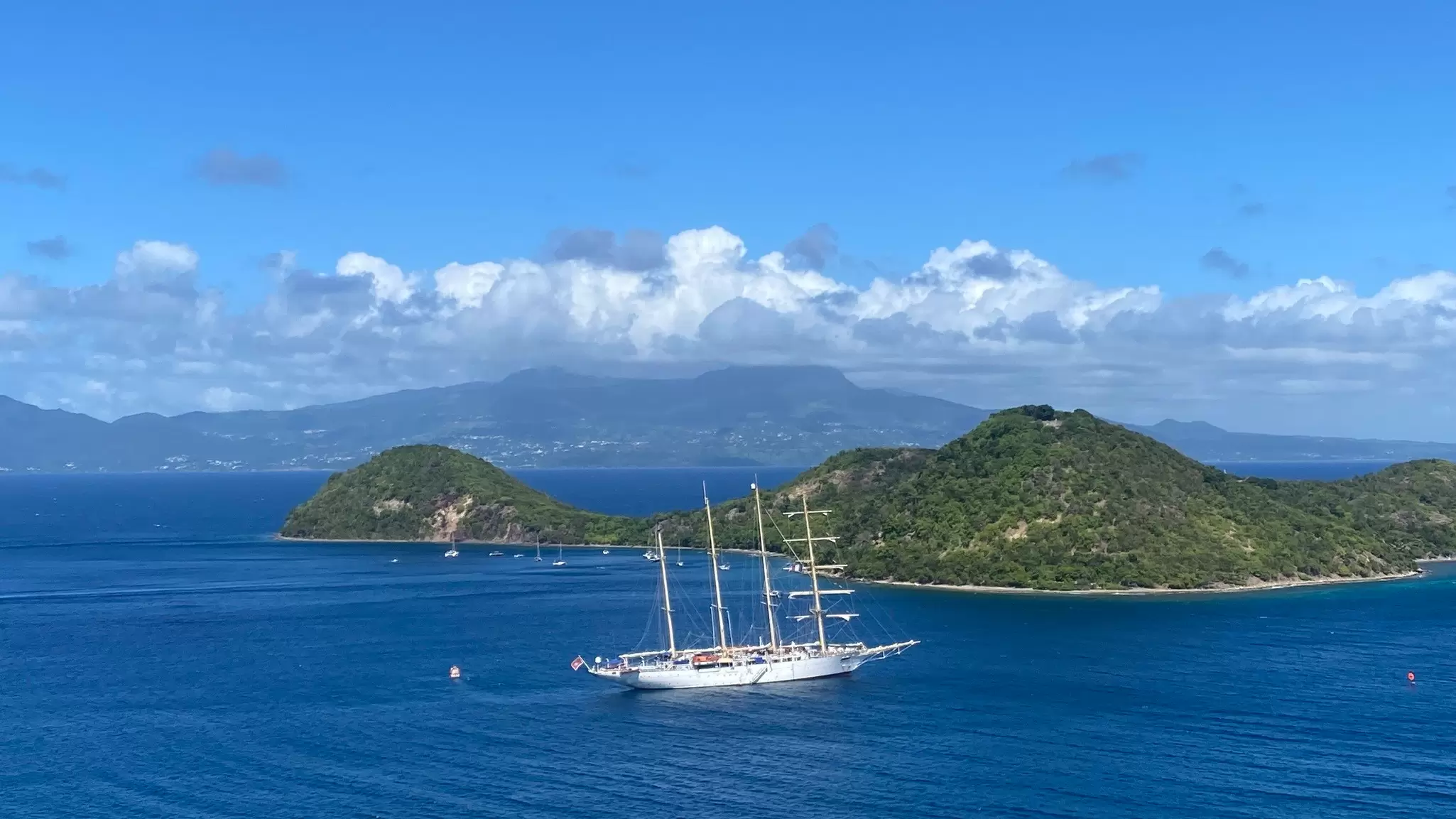 The blue waters off Guadeloupe, with La Soufrière, perpetually swathed in clouds, in the distance © Brian Healy