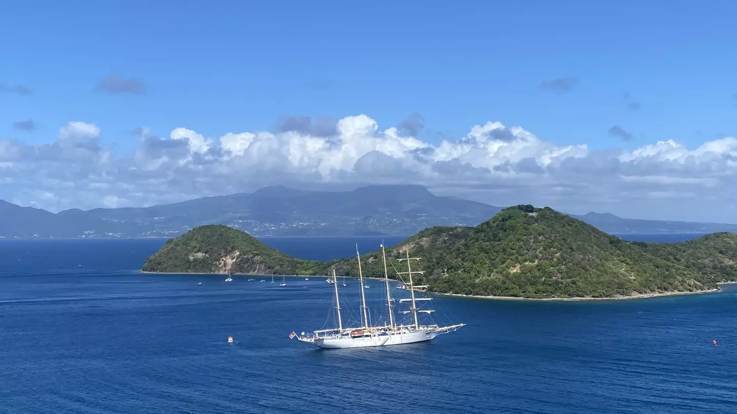 The blue waters off Guadeloupe, with La Soufrière, perpetually swathed in clouds, in the distance © Brian Healy