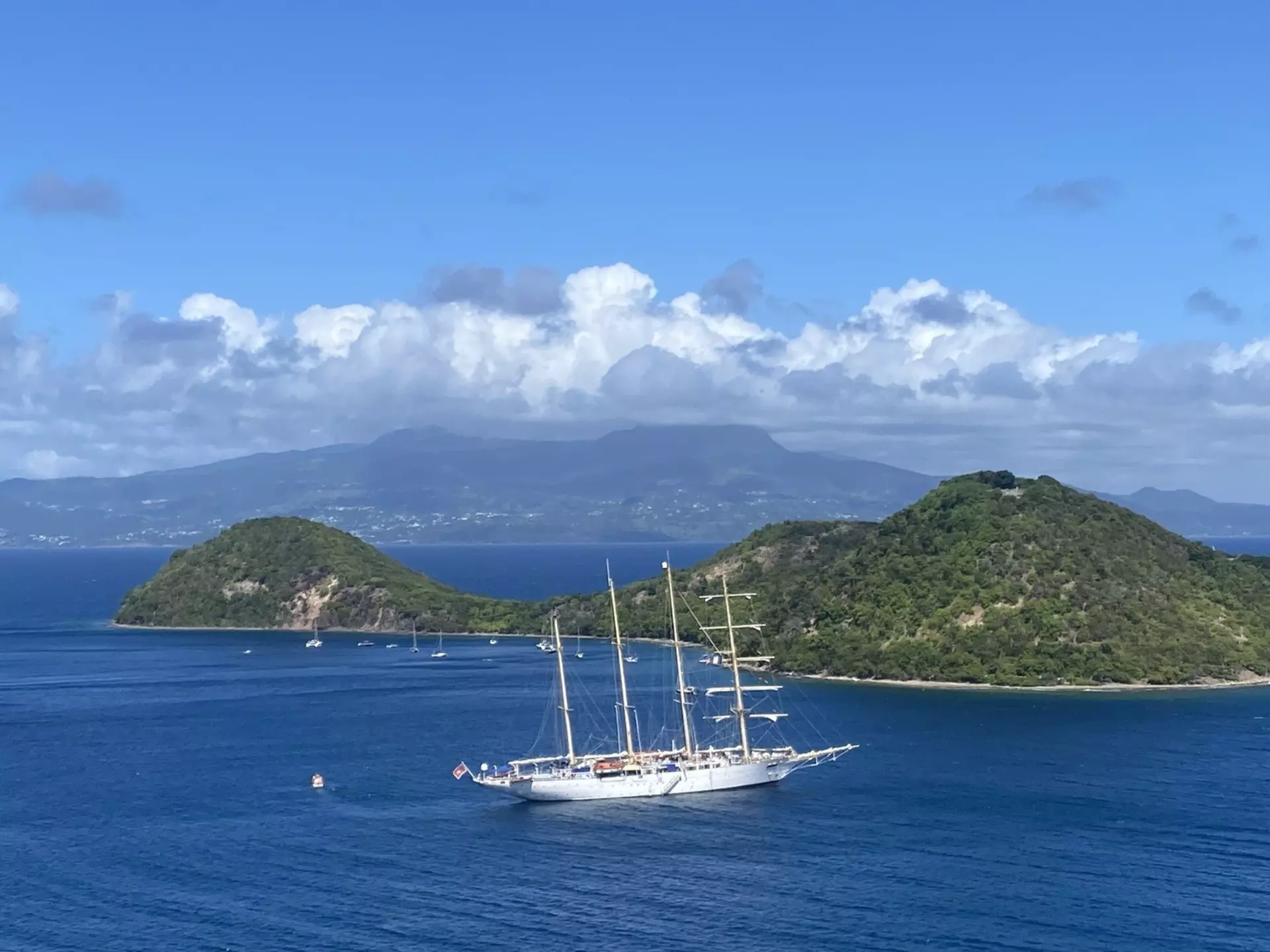 The blue waters off Guadeloupe, with La Soufrière, perpetually swathed in clouds, in the distance © Brian Healy