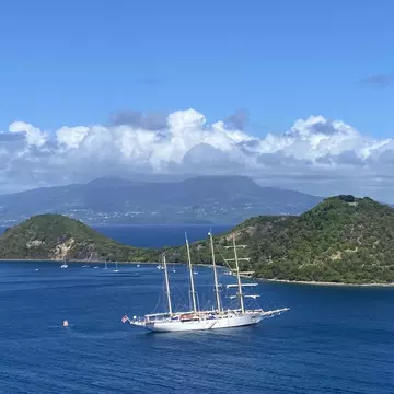 The blue waters off Guadeloupe, with La Soufrière, perpetually swathed in clouds, in the distance © Brian Healy