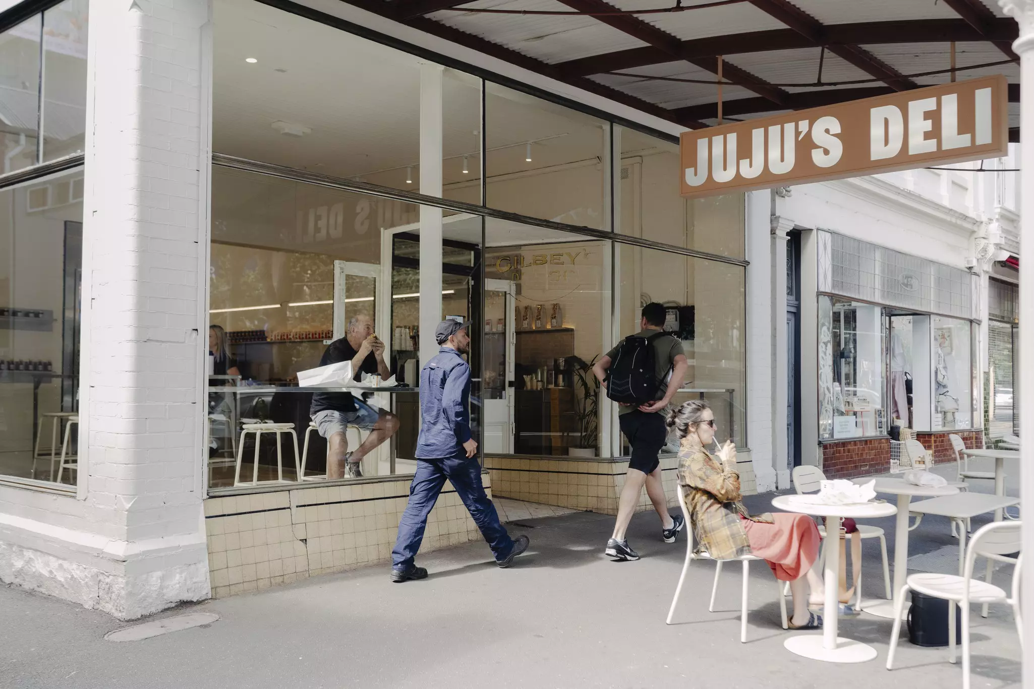 People walking by a sandwich shop