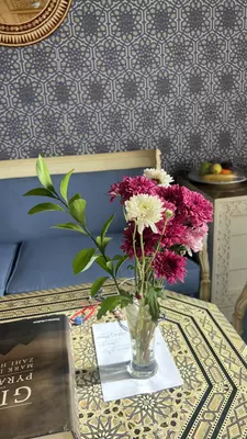 A vase of pink and white flowers on an inlay table