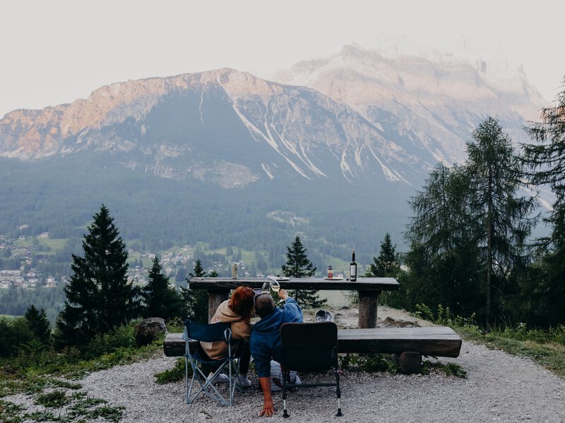 Cortina d'Ampezzo, Italy. June 2025. ..Enjoying the mountain views  while drinking wine and eating grilled meat, with the view of Sorapis and Antelao Mountains. ..Photo by Camilla Ferrari for Lonely Planet