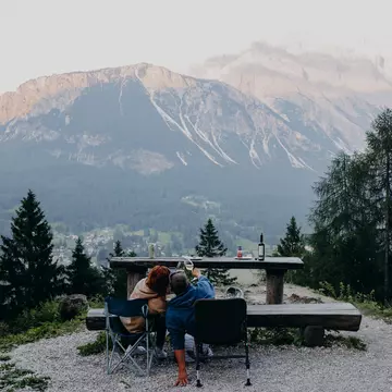 Cortina d'Ampezzo, Italy. June 2025. ..Enjoying the mountain views  while drinking wine and eating grilled meat, with the view of Sorapis and Antelao Mountains. ..Photo by Camilla Ferrari for Lonely Planet