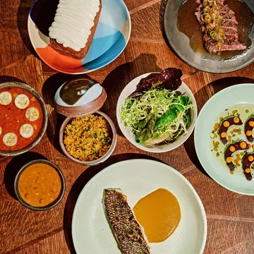 Black bass served with curry, yellow rice, and a side salad, skirt steak, pepper shrimp, cassava dumplings, and the coconut turnover at Kabawa in the East Village, NYC