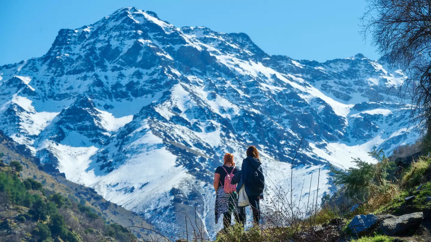 Hikers admire a view of the Sierra Nevada mountains in Andalucía, Spain