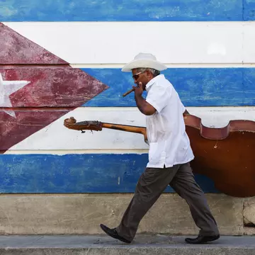 Cuban musician in front of the country's flag. Jeremy Woodhouse/Getty Images