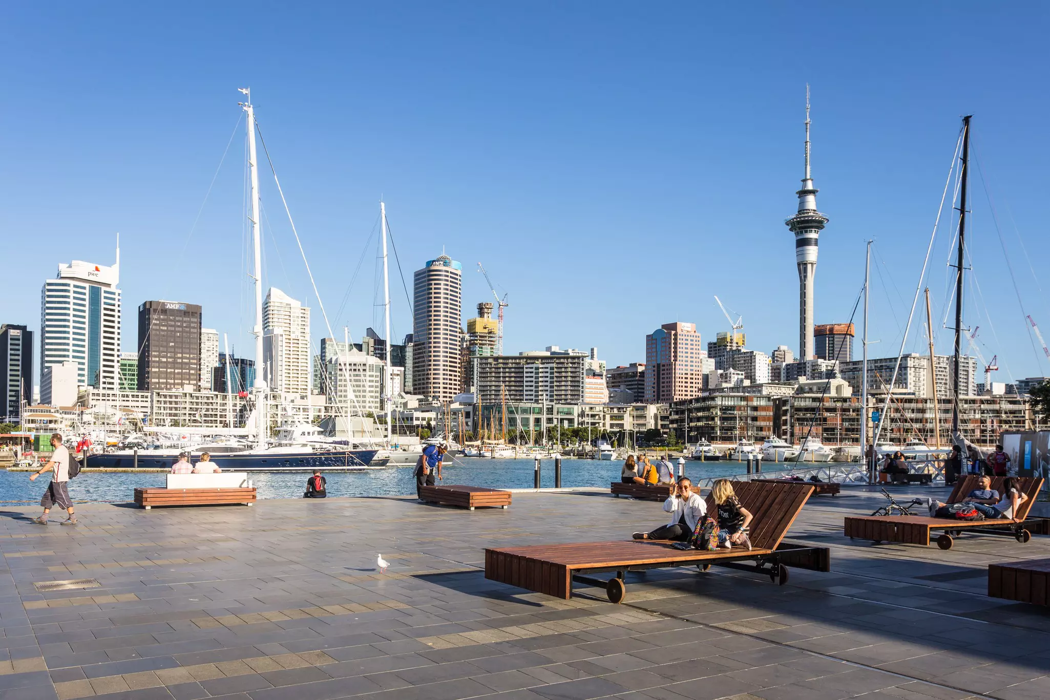 AUCKLAND, NEW ZEALAND - FEBRUARY 22, 2017: People relax on large wooden public long chairs in the Wynyard Quarter, Auckland's newest and tendy waterfront neighbourhood in New Zealand largest city., License Type: media, Download Time: 2025-07-25T19:31:44.000Z, User: rhylton_redventures, Editorial: true, purchase_order: 65050 - Digital Destinations and Articles, job: Lonely Planet , client: wip, other: Rhianydd Hylton