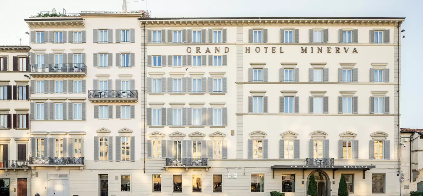 facade of a grand hotel building with a rooftop and a sign that reads "Grand Hotel Minerva"