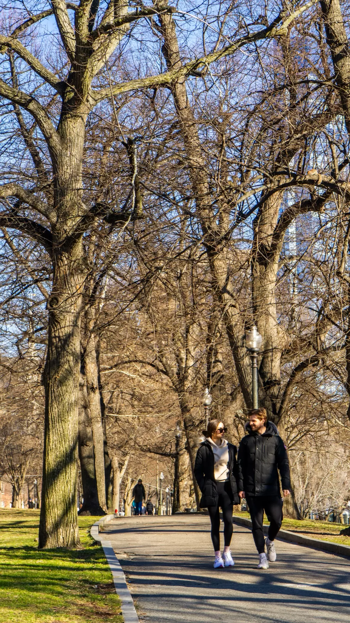 A couple walking along a path in Boston Common in Boston, Massachusetts.