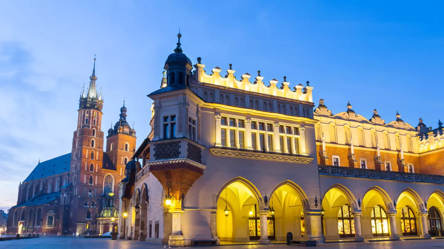Illuminated Sukiennice building and St. Mary's Church at night, Krakow, Poland