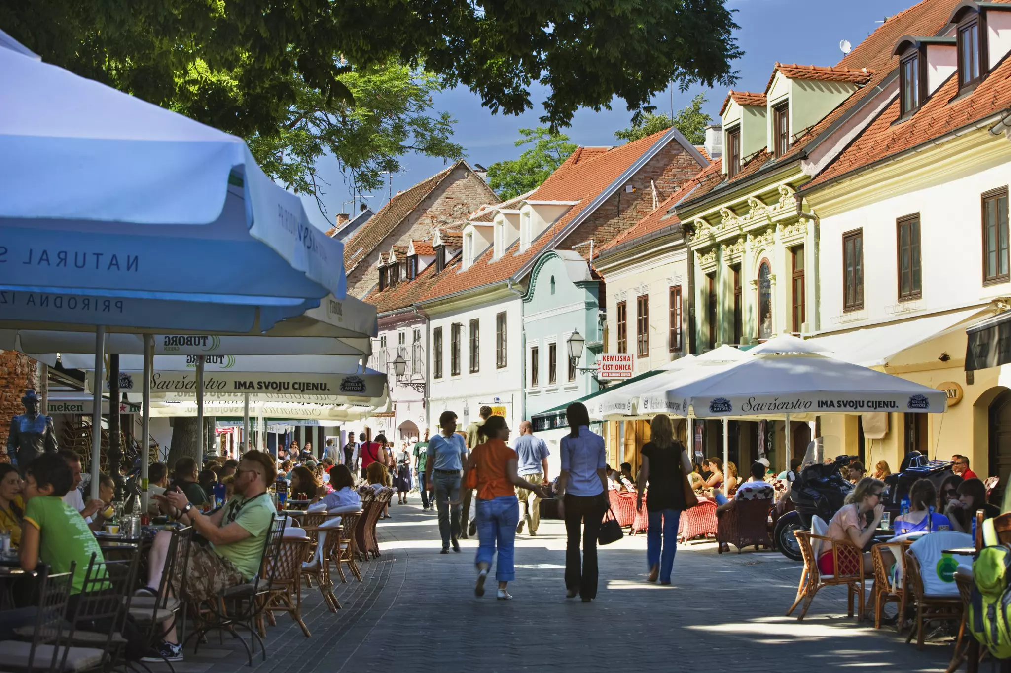 People sitting in cafes along a walkway in Zagreb, Croatia.
